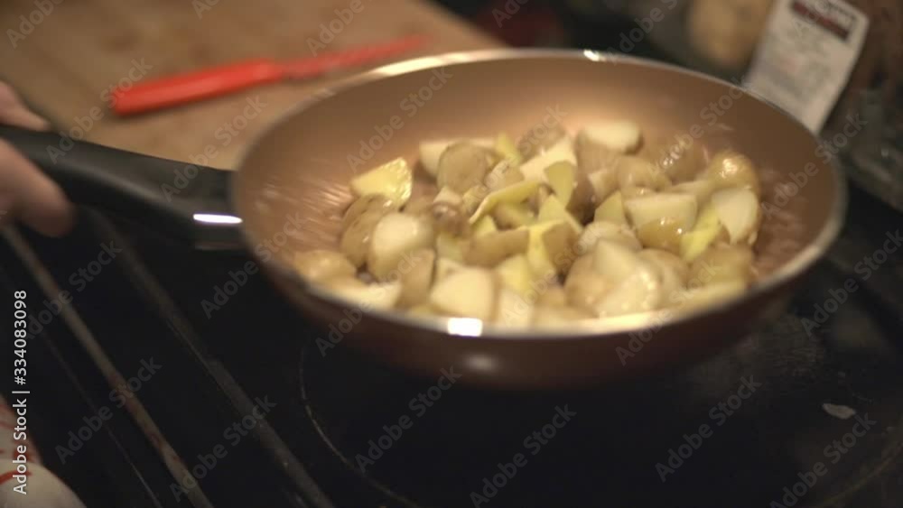 Shaking Off The Pan Full Of Quartered Potatoes By Moving It Forward And Backward. -close up shot Shaking Off The Pan Full Of Quartered Potatoes By Moving It Forward And Backward. -close up shot