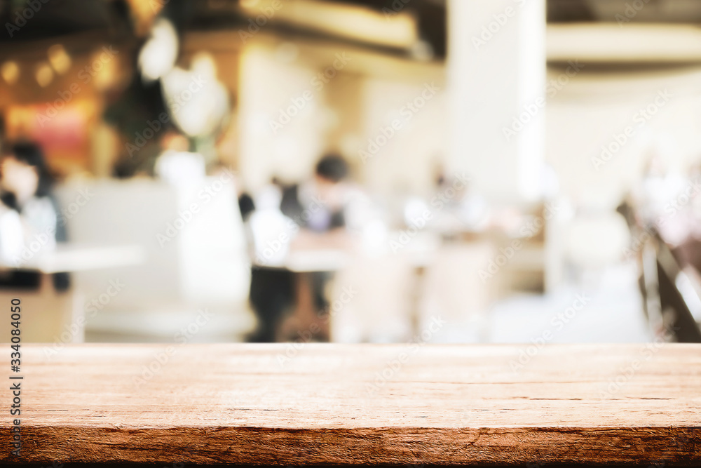 Empty wooden desk space and blurry background of restaurant vintage tone for product display montage Empty wooden desk space and blurry background of restaurant vintage tone for product display montage