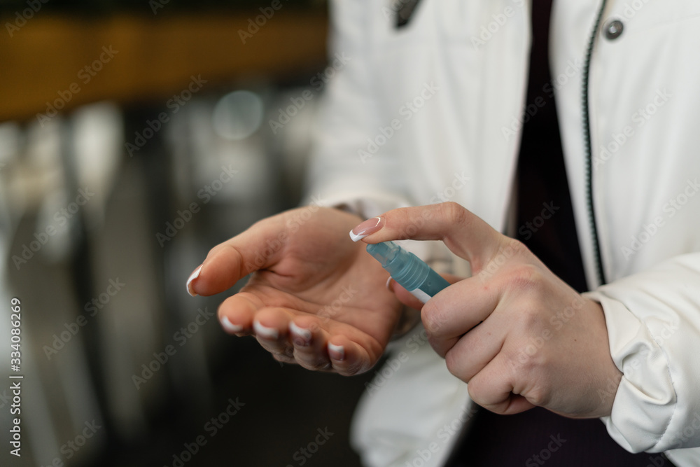 Treatment of female hands with an antiseptic in a public place. Antibacterial gel and disinfectant.