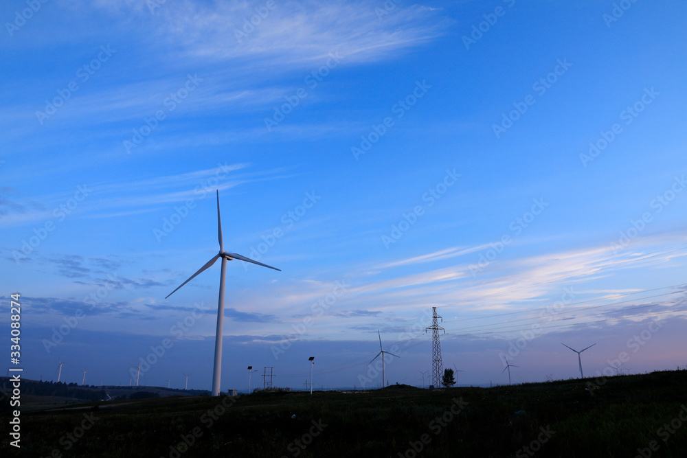 Obraz premium The windmill in the sunset, on the hillside