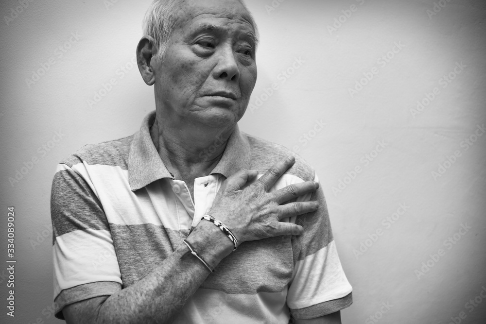 Obraz premium Elderly Asian man put his hand on his shoulder because of shoulder pain or muscle pain. Black and white tone. Healthcare and Medical concept.