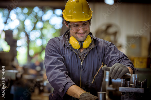 Close up portrait industry engineering wearing safety uniform control operating fixed machine working in industry factory.