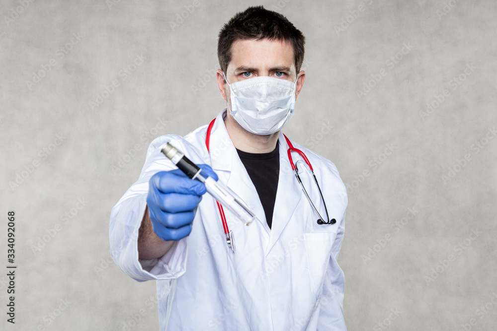 young doctor in a protective mask and gloves holds a coronavirus test in his hands young doctor in a protective mask and gloves holds a coronavirus test in his hands