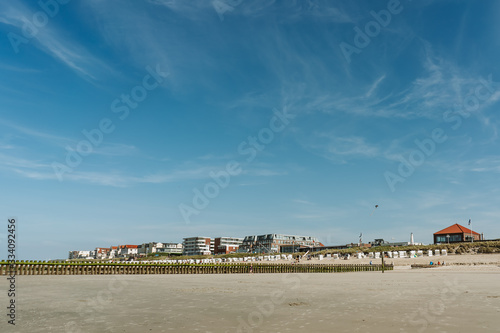 View over the ocean, the beach and the village of Wangerooge, Germany. Blue sky, sunny day.