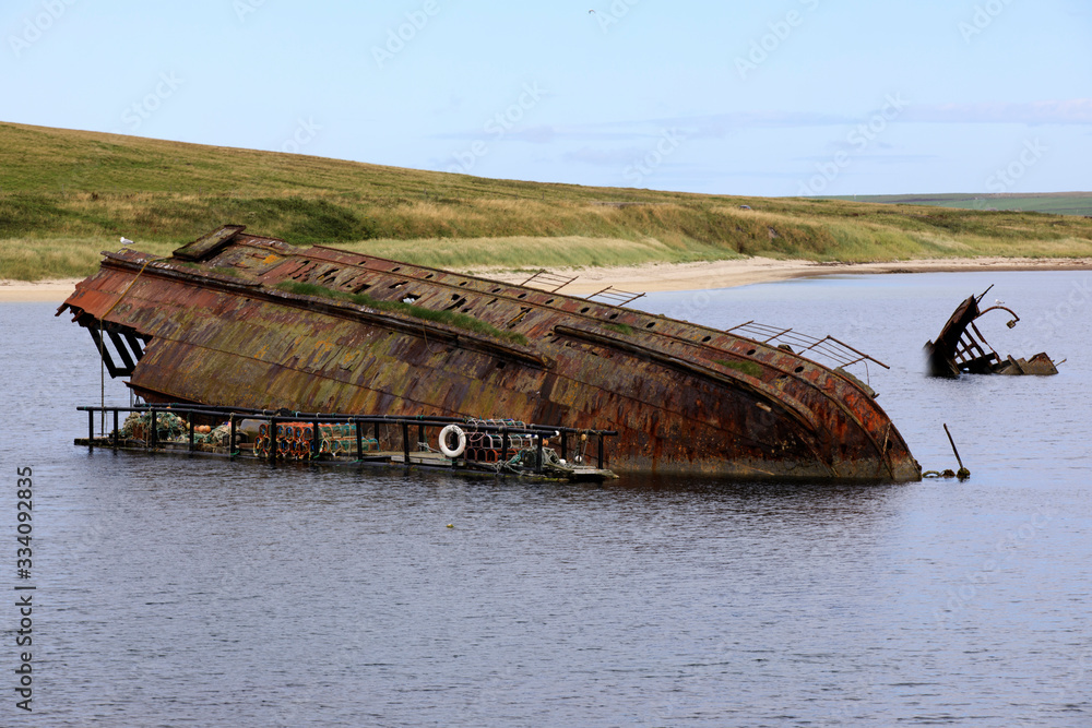 Orkney (Scotland), UK - August 06, 2018: World War II boat intentionally sunk to protect the natural harbour of Scapa Flow, Orkney, Scotland, Highlands, United Kingdom Orkney (Scotland), UK - August 06, 2018: World War II boat intentionally sunk to protect the natural harbour of Scapa Flow, Orkney, Scotland, Highlands, United Kingdom