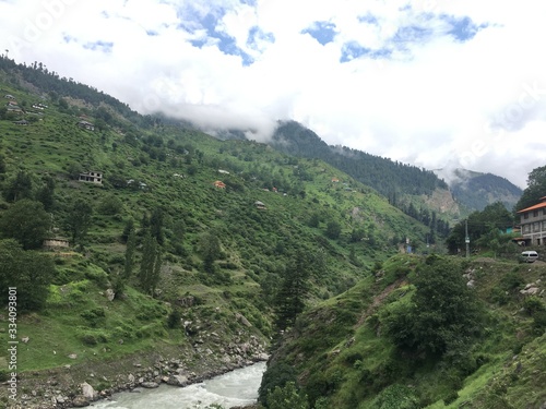 CLOUDS ON SKY BELOW RIVER BETWEEN SNOW ON MOUNTAINS