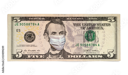 Coronavirus COVID-19 in USA. Quarantine and global recession. Abraham Lincoln in healthcare surgical mask on a five dollar bill. Global economy hit by corona virus outbreak and pandemic. photo