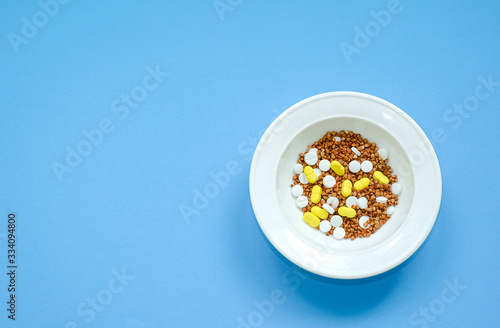 Buckwheat in a white plate mixed with tablets