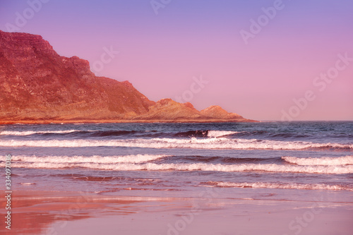 Rocky sea shore at sunset. Seascape in the evening. Sandy beach