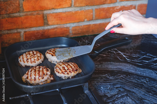 Fresh meat cutlets in a grill pan. Juicy meat steak in a pan. Cooking a burger at home. Delicious and healthy food concept.