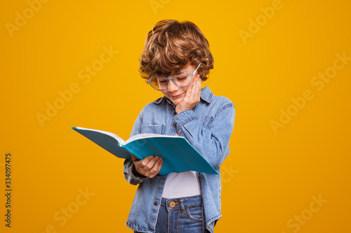 Little boy reading interesting book photo