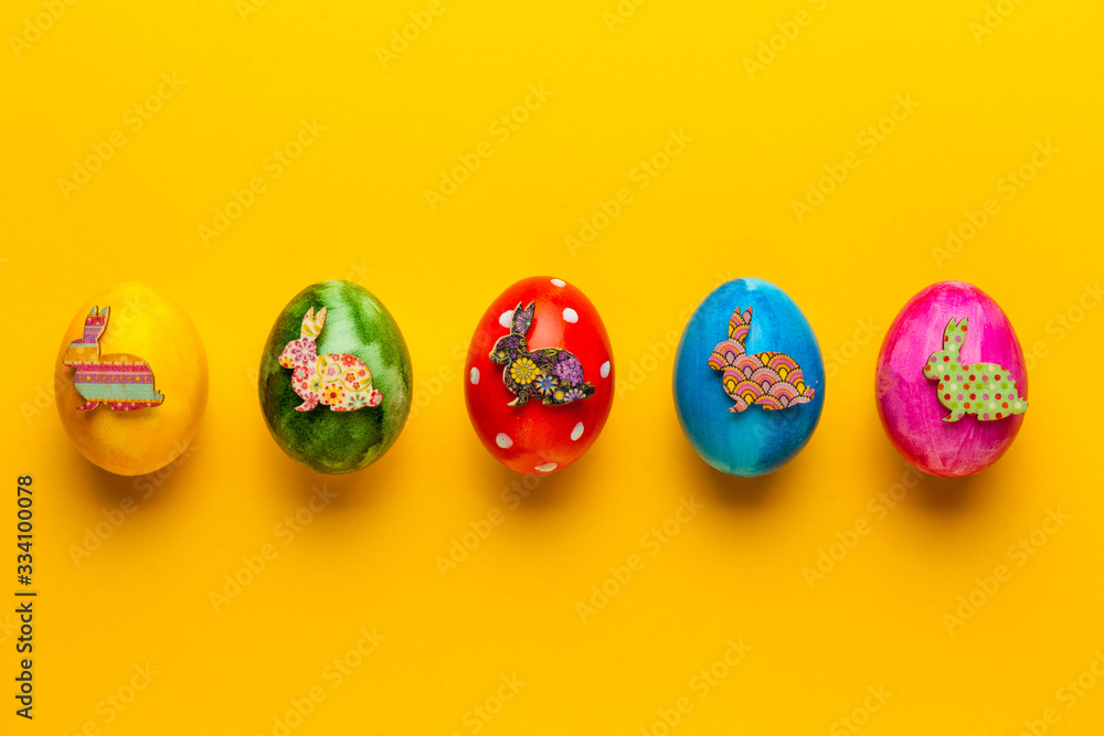 Bright easter eggs with bunny (rabbit) on yellow background. Retro colorful spring decoration.