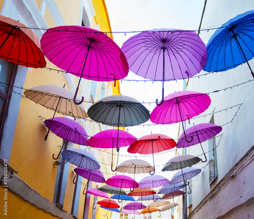 Multi-colored umbrellas in sky above street