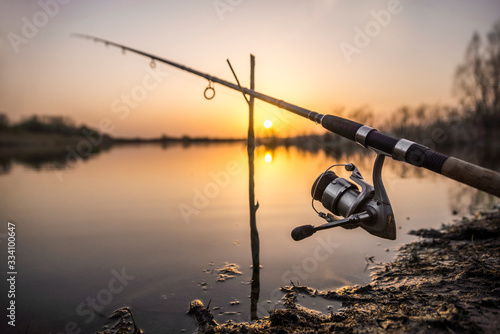 feeder fishing rod isolated on lake sunset. fishing backgrounds