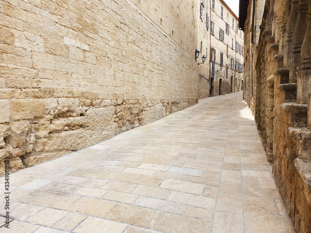 A narrow, deserted street in San Marino with ancient, stone houses.