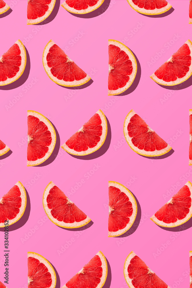 Fruit summer pattern. Flat lay composition grapefruit slice close up on pink background