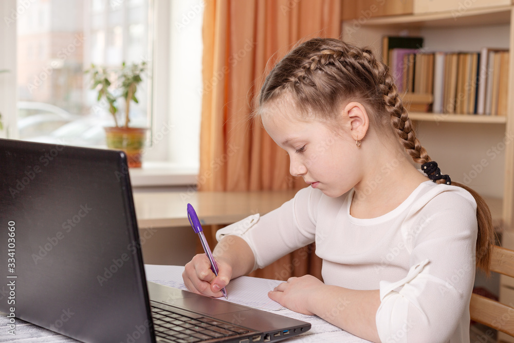 Schoolgirl does homework. Social distance, self-isolation. Home school, online education, home education, quarantine concept Schoolgirl does homework. Social distance, self-isolation. Home school, online education, home education, quarantine concept