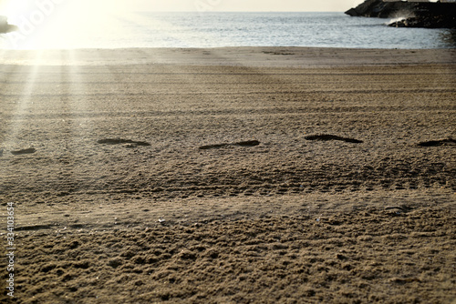 Cullera, Valencia, Spain: 02.08.2018; The footprint in the sunlight rays on the beach photo