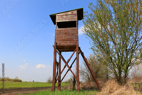 wooden hunter hut on clear blue sky background
