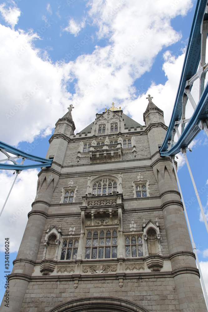 Top part of Tower Bridge with the blue sky and clouds on a bright sunny day in spring, London, UK