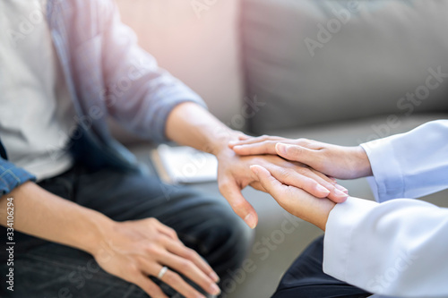 close up of doctor and patient holding hand  female doctor hands coupling the patients hand in comfort on bad news of relatives or positive testing on illness and diseases in hospital or clinic office