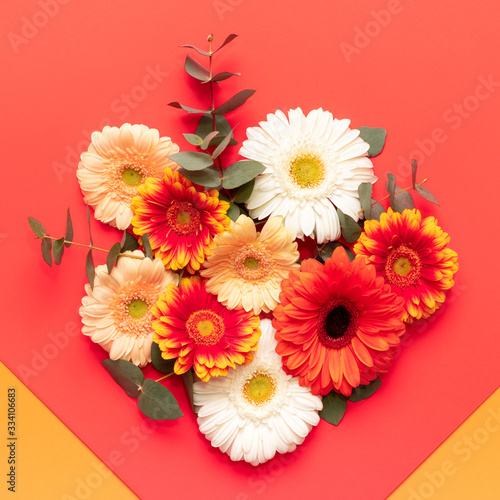 Happy Mother's Day, Women's Day, Valentine's Day or Birthday Living Coral and Lush Lava Background. Floral flat lay greeting card with beautiful gerberas.