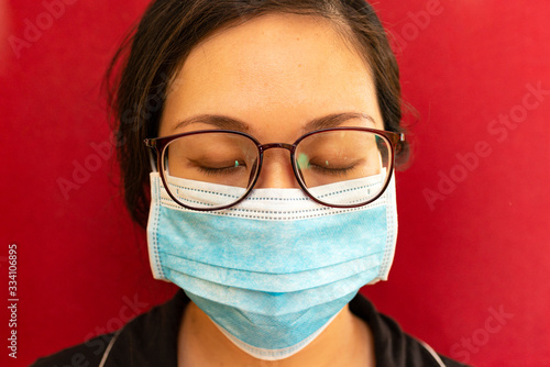 Tired Asian Woman after a long Day Working Using a Mask against Coronavirus