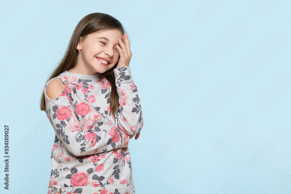 Wow. Studio portrait of an adorable young schoolgirl holding her head in disbelief, isolated on pastel blue background. Human emotions and facial expressions concept. Wow. Studio portrait of an adorable young schoolgirl holding her head in disbelief, isolated on pastel blue background. Human emotions and facial expressions concept.
