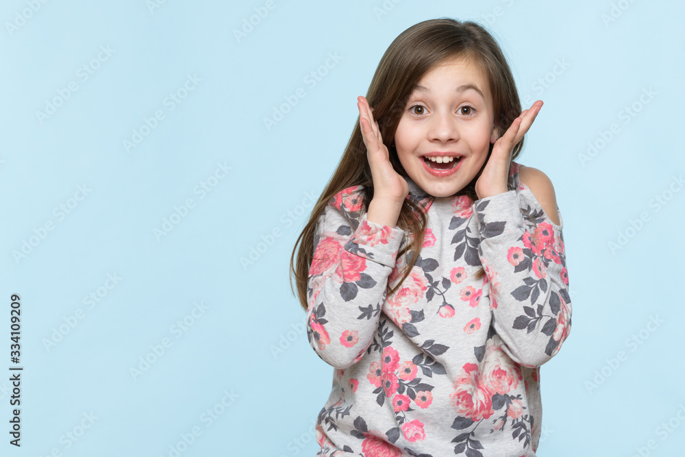 Wow. Studio portrait of an adorable young schoolgirl screaming with excitement, isolated on pastel blue backgroud. Human emotions and facial expressions concept. Wow. Studio portrait of an adorable young schoolgirl screaming with excitement, isolated on pastel blue backgroud. Human emotions and facial expressions concept.