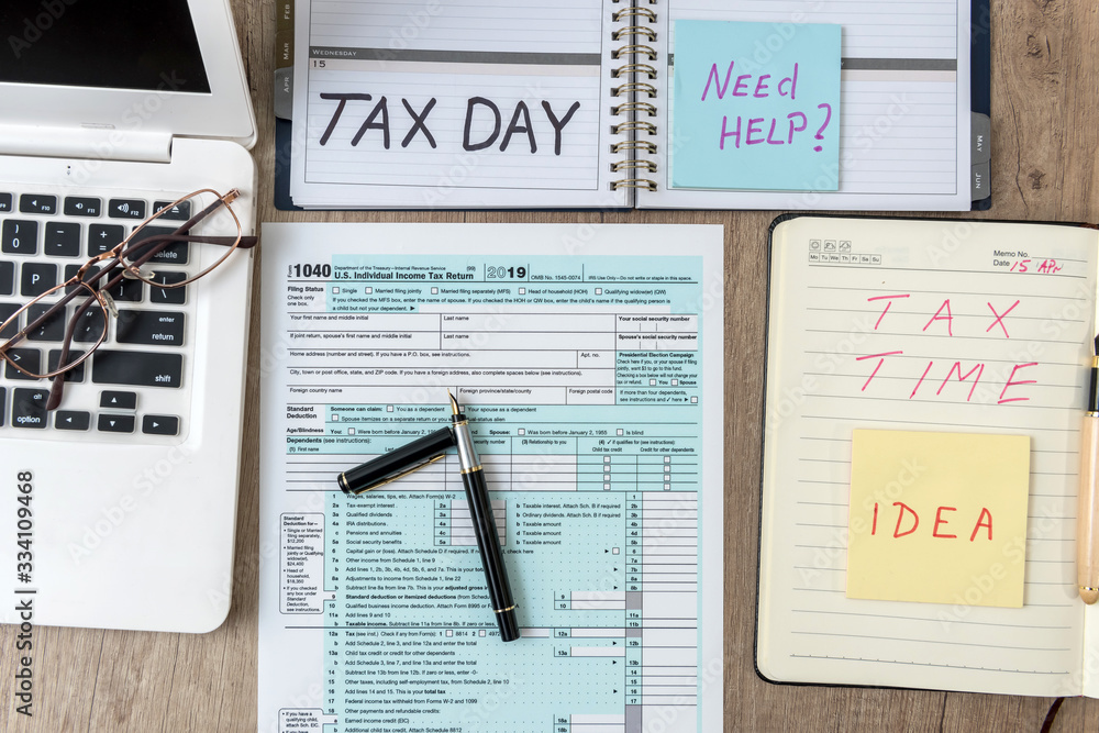 1040 USA individual tax form with laptop computer notepad, pen, sticker on  a table, office workplace. Tax concept. Stock-Foto | Adobe Stock