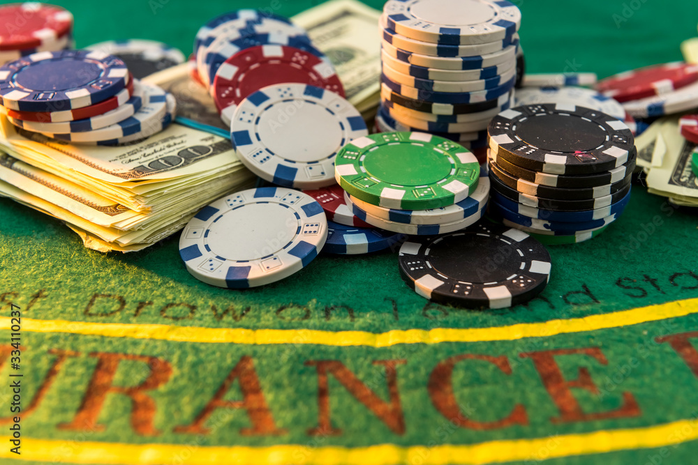 Casino chips with dollar bills on green poker table. Risk or win Casino chips with dollar bills on green poker table. Risk or win