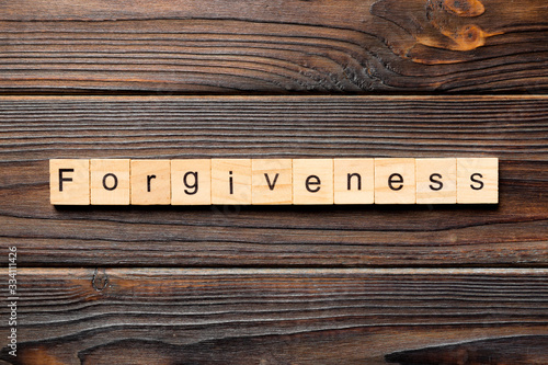 forgiveness word written on wood block. forgiveness text on table, concept photo