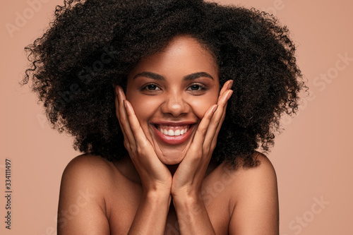 Positive African American woman with healthy skin looking at camera