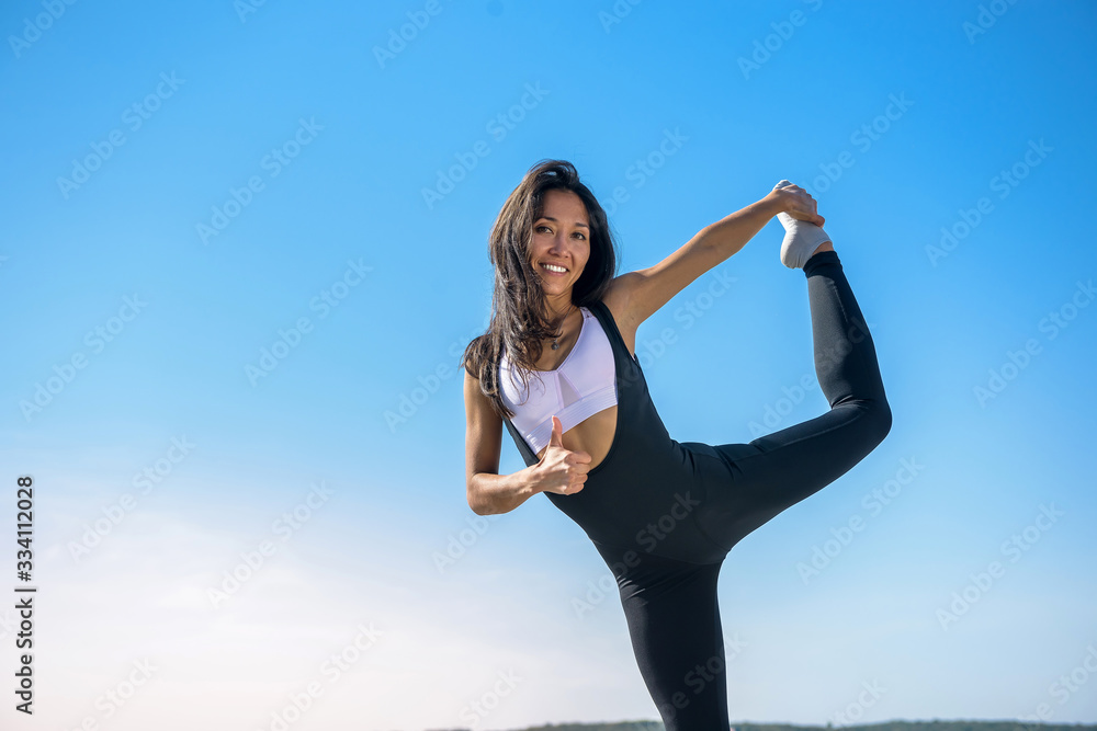 Sportive woman doing yoga exercise in the park, near the lake at daytime. Healthy lifestyle concept. Sportive woman doing yoga exercise in the park, near the lake at daytime. Healthy lifestyle concept.