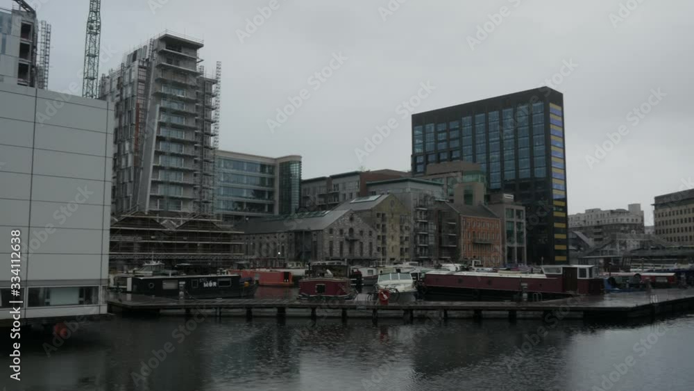 Pan shot showing new modern buildings by the riverside in Dublin,Ireland during dust Pan shot showing new modern buildings by the riverside in Dublin,Ireland during dust
