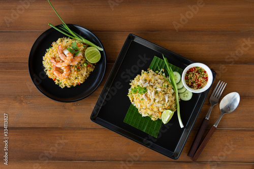 Thai fried rice with crab meat (Khao pad poo) and Shrimp fried rice on a wood Background. Top view