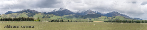 green landscape with snow on Takitimu mountains, near The Key, New Zealand