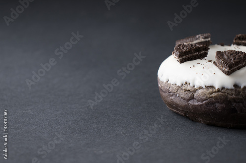 chocolate donut in white glaze on a black background