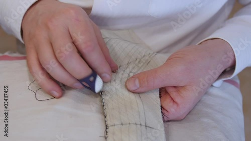 Fashion designer hands pad stitching a collar. Pad stitches secure two or more layers of fabric together and give the layers more firmness; smaller and denser stitches create more firmnes