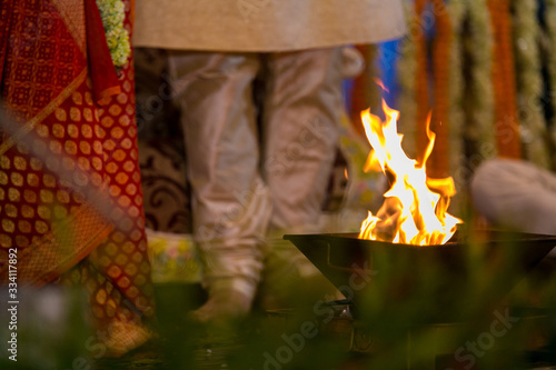 Indian Bride and Groom stand near the sacred fire called (Havan) photo