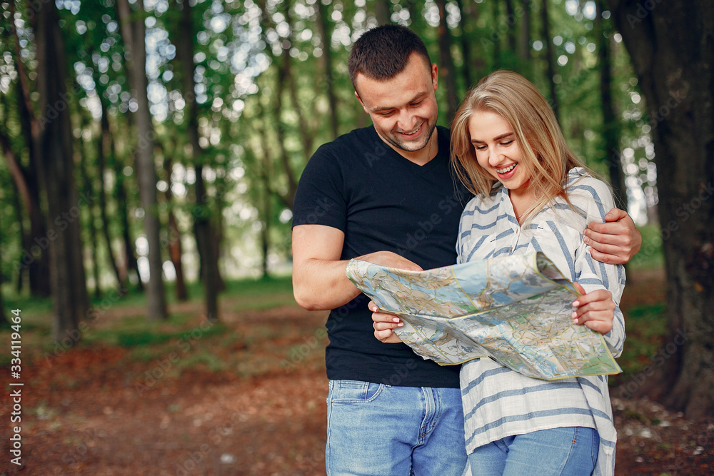 Tourists in a summer forest. Couple with a map. Tourists in a summer forest. Couple with a map.