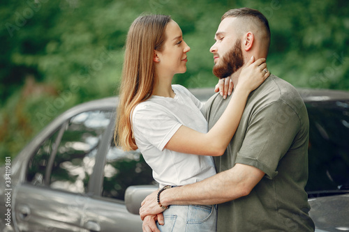 Couple in a forest. Man in a green t-shirt. Pair near car
