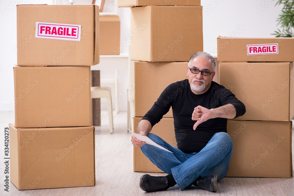 Old male professional mover doing home relocation Old male professional mover doing home relocation