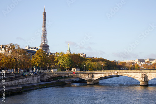 Eiffel tower, bridge and Seine river view with autumn trees in a sunny day in Paris, France