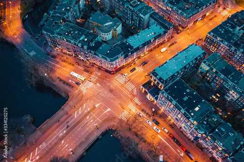 Photography Beautiful night aerial view of Amsterdam downtown from above with illuminated streets and car traffic, old historic houses, drone photo