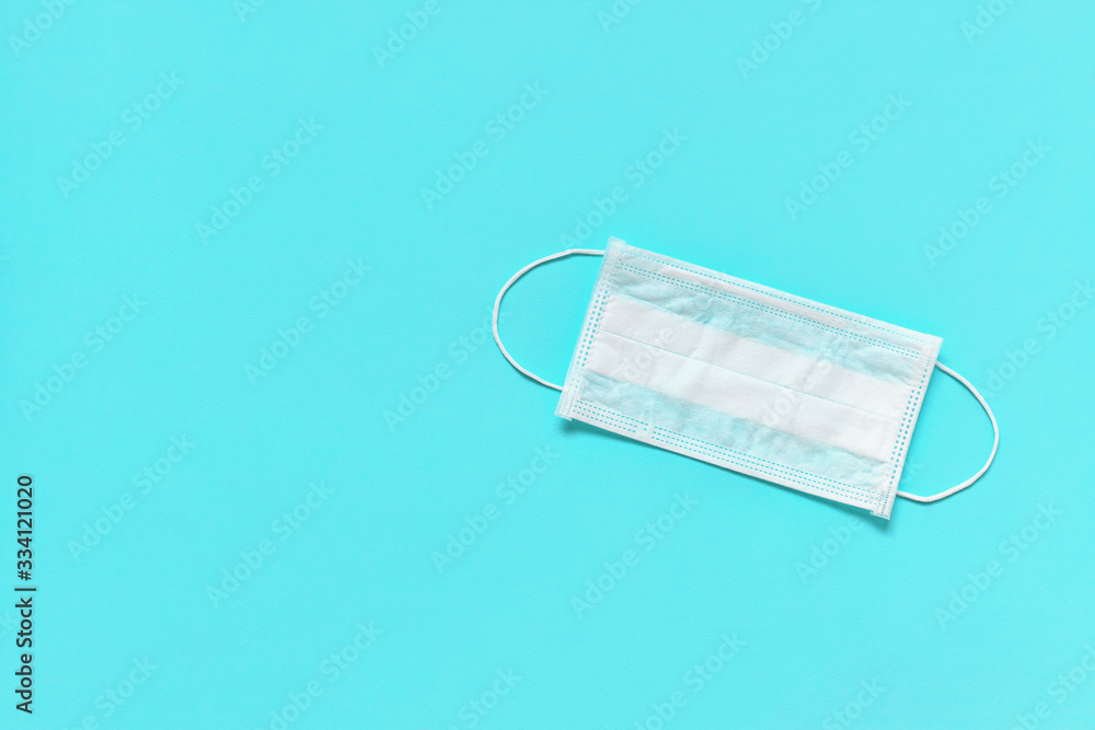 Medical mask for protection against flu or virus on blue background. Prevention concept. Top view, copy space Medical mask for protection against flu or virus on blue background. Prevention concept. Top view, copy space