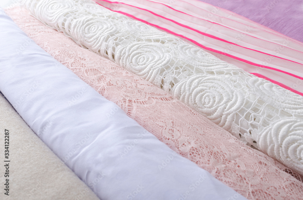 Retail assortment of fashion fabrics.Bright and soft silk, cotton, lace, corrugated fabric as a background Retail assortment of fashion fabrics.Bright and soft silk, cotton, lace, corrugated fabric as a background