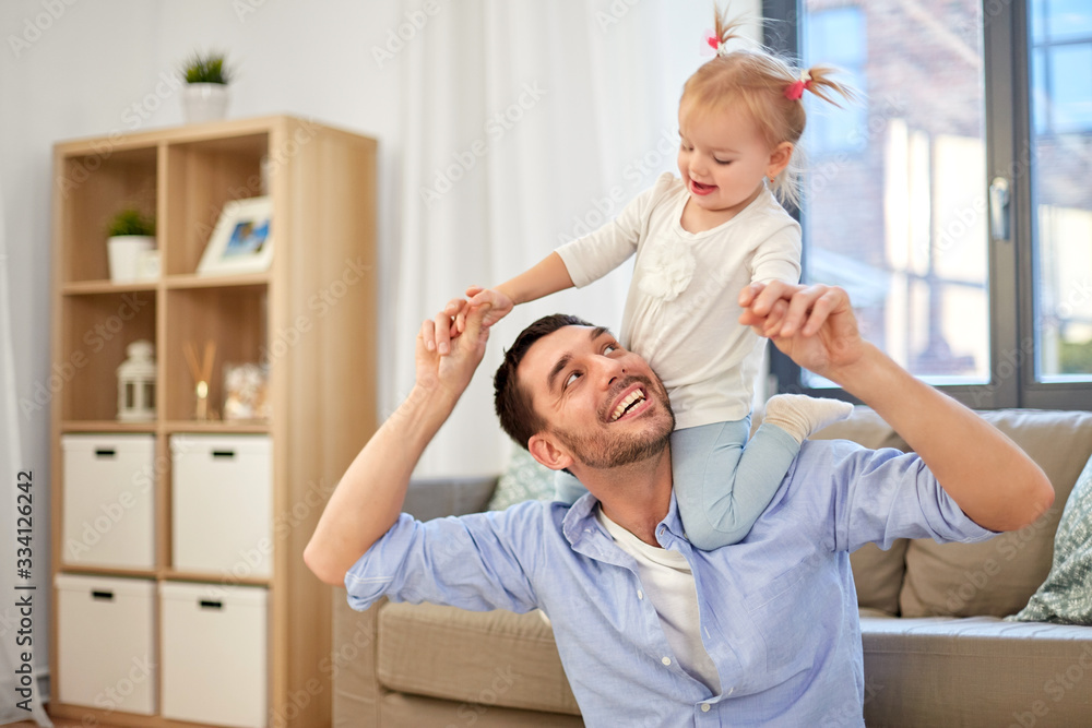 Fototapeta premium family, parenthood and fatherhood concept - happy father riding little baby daughter on his neck at home