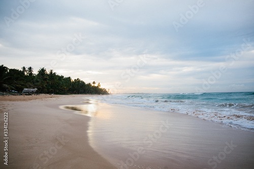 The coast of the Indian Ocean at dawn in Sri Lanka in March 2020. Calm beautiful water and azure blue waves