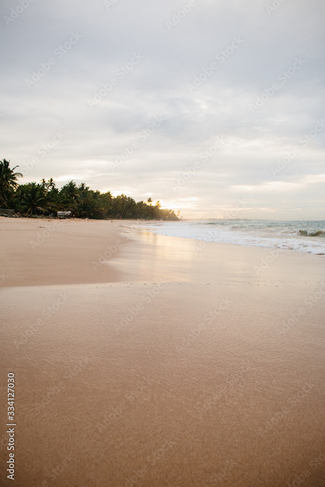 The coast of the Indian Ocean at dawn in Sri Lanka in March 2020. Calm beautiful water and azure blue waves The coast of the Indian Ocean at dawn in Sri Lanka in March 2020. Calm beautiful water and azure blue waves
